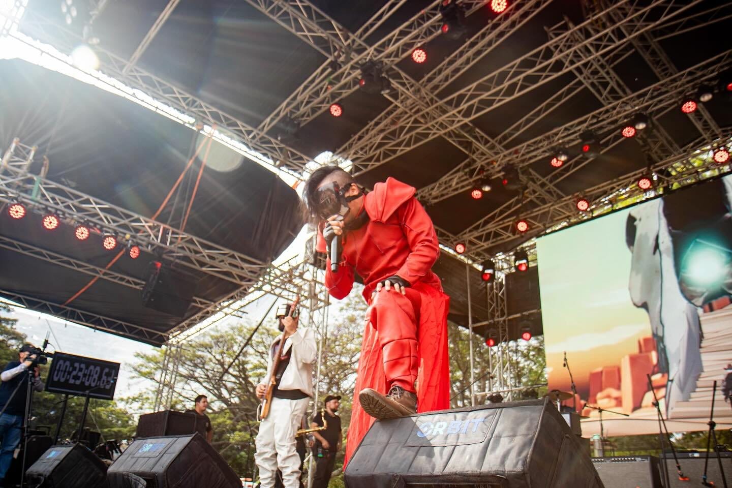 El vocalista de Rex Marte con traje rojo bajo el techo del escenario