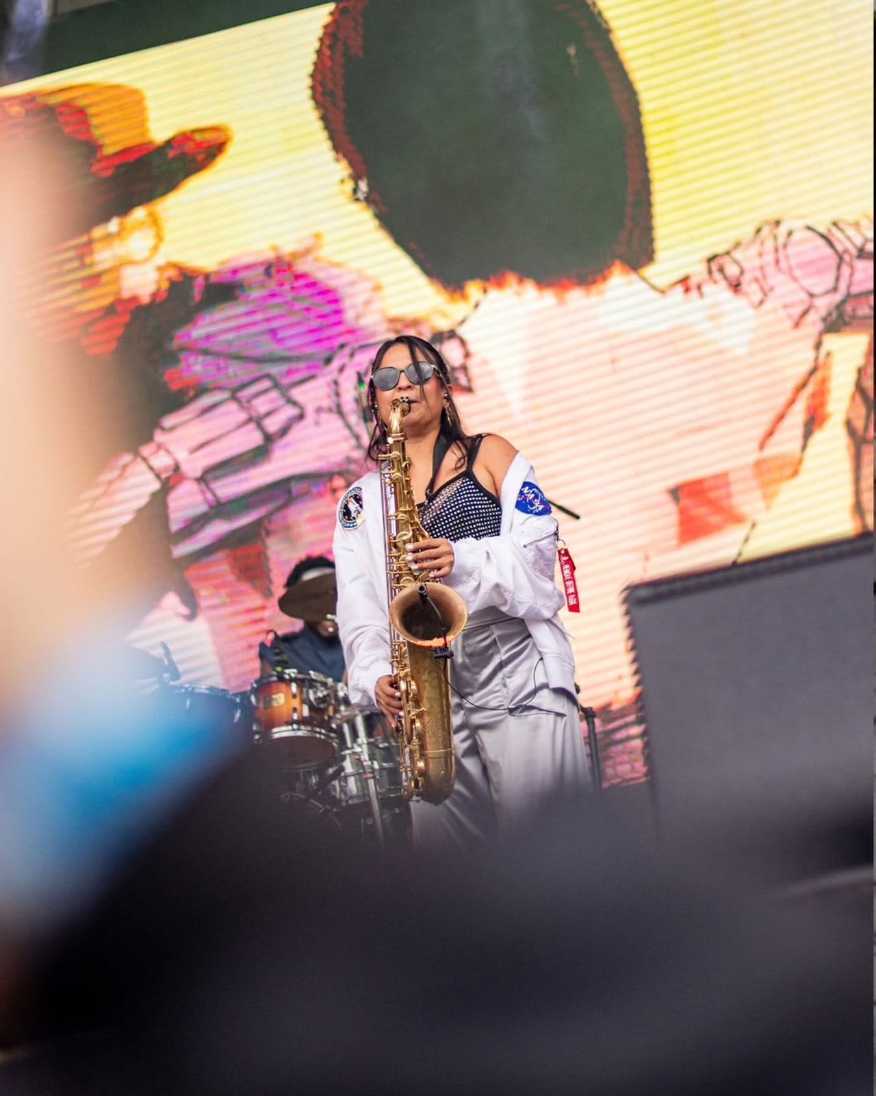 La saxofonista invitada frente a la pantalla del escenario